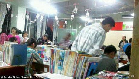 Un insegnante guarda sopra la spalla di uno studente cinese nella provincia di Hubei mentre studiano, mentre agganciato alla flebo