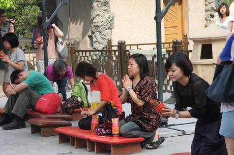 Donne con i bastonici per predire il futuro nel tempio taoista di Wong Tai Sin, a Hong Kong. Foto di Marco Restelli