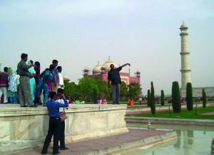Turisti indiani in visita al Taj Mahal, fanno il giochetto scemo della foto in prospettiva