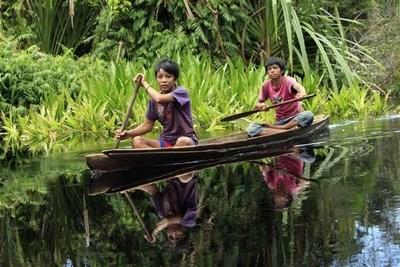 Giovani pescatori in canoa sul fiume Serkap nella foresta di Kampar a Sumatra