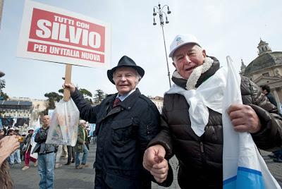 Comparse, figuranti e cloni. Il senso di Silvio per lo spettacolo: paga lui 10 euro a testa per farsi ascoltare.