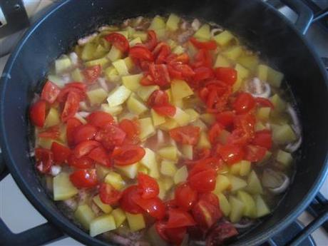Aggiungere le patate (tagliate e lavate precedentemente a cubetti) e i pomodorini (lavati e tagliati in 4 parti). Cuocere per 10 minuti (a coperchio chiuso) e aggiungere i moscardini.