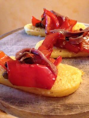 Crostini di polenta con peperoni, alici, olive taggiasche e capperi