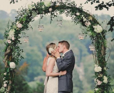 Coppia di sposi sotto un arco floreale