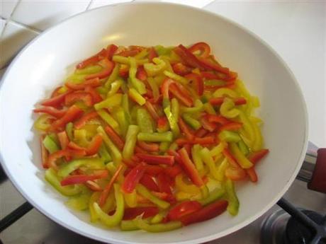In una padella far imbiondire leggermente l'aglio nell'olio, quindi toglierlo e versare i peperoni. 