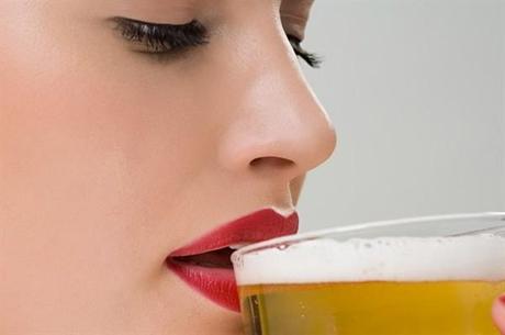 foto di una donna che beve un bicchiere di birra