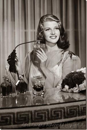 Actress Rita Hayworth with a collection of fragrances