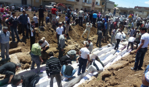 La sepoltura di massa del 26 maggio 2012, dopo il massacro di Hula (presstv.ir)