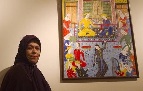 Zohre Etezadolsaltaneh,49, poses for a picture beside her painting at an exhibition in Tehran January 23, 2011. Etezadolsaltaneh, a retired special education teacher, was born with no arms but lives the life of an independent woman who has been doing cooking, painting, weaving kilims and taking care for her mother who is a cancer patient. She gets $600 per month as pension from the government and lives by the mantra 