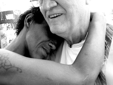 Padre Renato abbraccia un transessuale dipendente da crack che vive abbandonato nella Cracolandia della Zona Norte di Rio de Janeiro