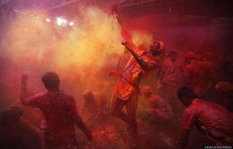 Hindu men from the village of Nangaon throw colored powder on others as they play holi at the Ladali or Radha temple before the procession for the Lathmar Holi festival, the legendary hometown of Radha, consort of Hindu God Krishna, in Barsana 115 kilometers ( 71 miles) from New Delhi, India, Sunday, March 9, 2014. During Lathmar Holi the women of Barsana beat the men from Nandgaon, the hometown of Krishna, with wooden sticks in response to their teasing as they depart the town. (AP Photo/Altaf Qadri)