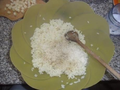 Riponete il riso in una ciotola. Salate e aggiungete il pepe nero (a vostro piacimento), metà del formaggio grattugiato