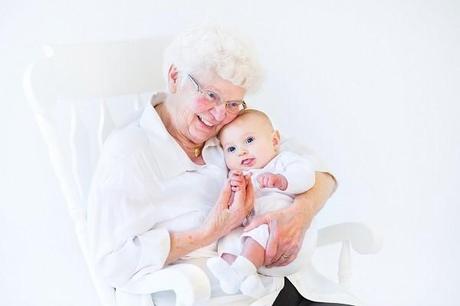 Beautiful grandmother singing to her newborn baby grandson sitti