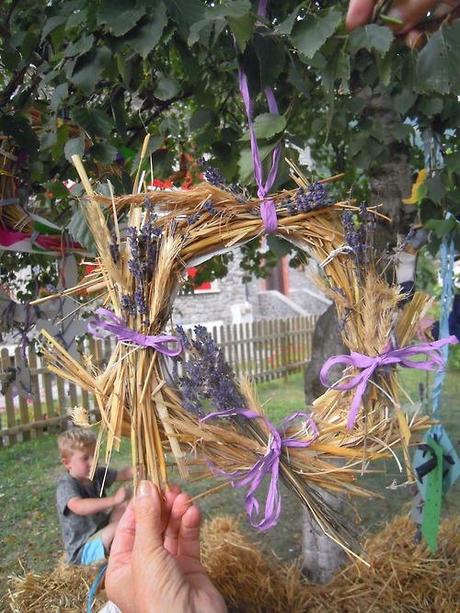 Piccole e grandi mani al lavoro con paglia di segale, lavanda e...