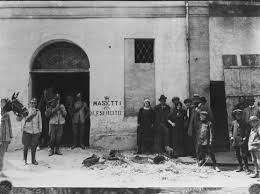 15 giugno 1914 Circolo Monarchico in via Roma ad Alfonsine, dopo la devastazione.  A sinistra la Cavalleria Regia, a destra alcuni degli stessi dimostranti, in posa. La scritta 