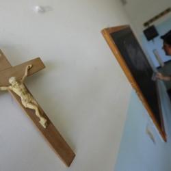 A crucifix is seen on a wall as a  teach