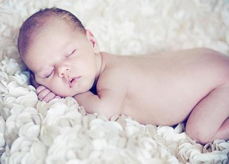 Cute baby sleeping on soft petals