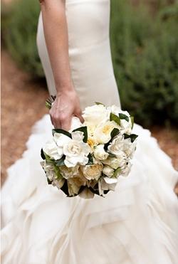 Bouquet di gardenie nelle mani di una sposa in bianco