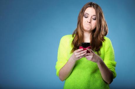 Funny girl with mobile phone reads message