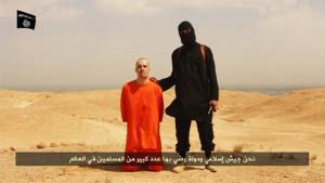 Still image from undated video of a masked Islamic State militant holding a knife speaking next to man purported to be James Foley at an unknown location