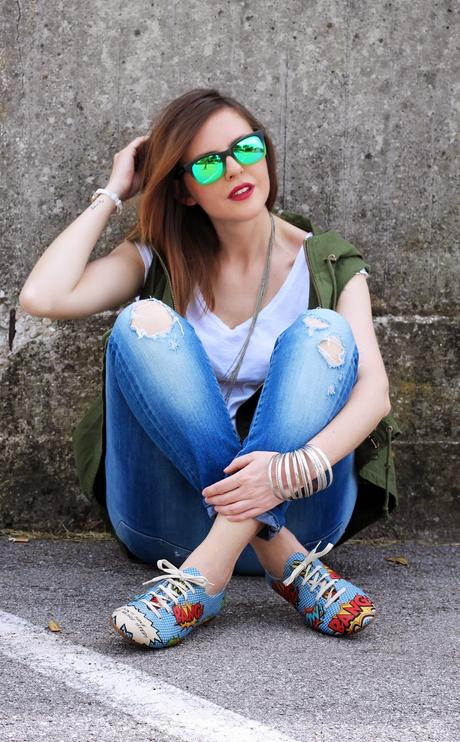 Outfit: Parka verde smanicato, ripped jeans e scarpe oxford con stampa fumetto