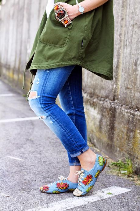 Outfit: Parka verde smanicato, ripped jeans e scarpe oxford con stampa fumetto