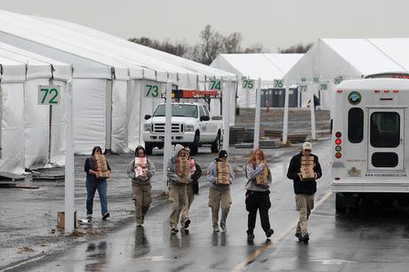Una scena da un campo FEMA del New Jersey dove si vedono civili che trasportano razioni e stand usabili come rifugio