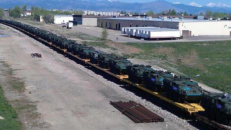 Le colonne di mezzi militari dell'ONU sopra i treni fermi negli USA in attesa di destinazione
