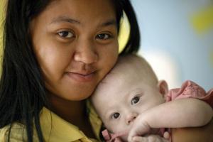Gammy, a baby born with Down's Syndrome, is held by his surrogate mother in Chonburi province