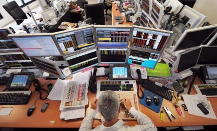 A trader has lunch in front of computers screens on August 19, 2011 at the office of the French investment company Aurel BGC in Paris. Global stocks tumbled further and safe bet gold surged to new records on August 19, 2011 on mounting fears of fresh g...
