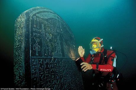 A Londra le città sommerse d’Egitto Diver Franck Goddio poses with an inscribed tablet he found in the ruins of Heracleion in Aboukir Bay, Egypt.