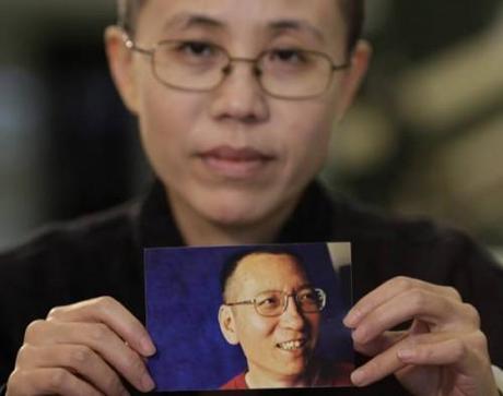 Liu Xia, the wife of Chinese dissident Liu Xiaobo, holds a photo of Liu Xiaobo during an interview in Beijing