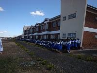 I bambini davanti all'ingresso della nuova scuola