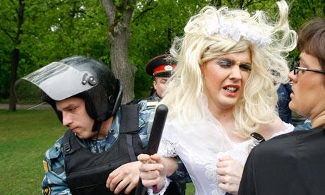 Un poliziotto russo detiene un uomo vestito con un abito da sposa durante una protesta dei diritti gay a Mosca