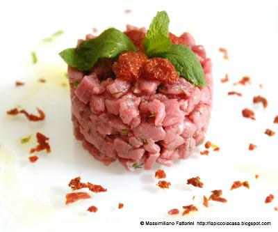 La carne cruda: tartare di girello con coriandoli di pomodori ciliegini, finocchietto selvatico, sale al peperoncino chipotle affumicato e emulsione di olio evo e yerba buena