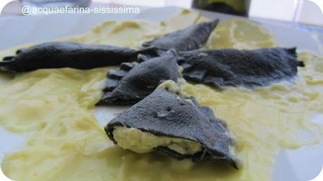 Ravioli al nero di seppia ripieni di pesto di pistacchi su letto di besciamella allo zafferano