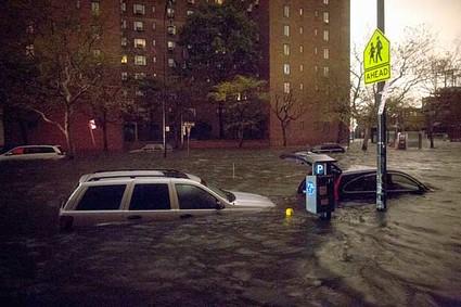 Vehicles are submerged on 14th Street near the Consolidated Edison power plant, Monday, Oct. 29, 2012, in New York. Sandy continued on its path Monday, as the storm forced the shutdown of mass transit, schools and financial markets, sending coastal residents fleeing, and threatening a dangerous mix of high winds and soaking rain.  