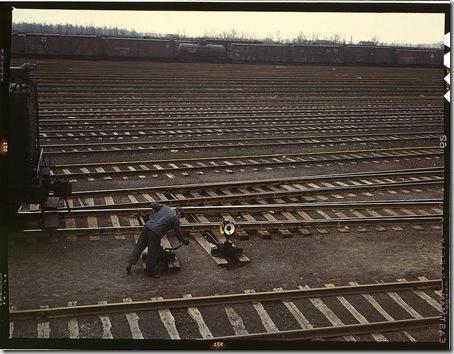 Switchman throwing a switch at Chicago and Northwest Railway Company's Proviso yard. Chicago, Illinois, April 1943. Reproduction from color slide. Photo by Jack Delano. Prints and Photographs Division, Library of Congress