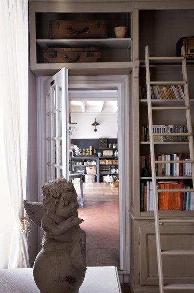 Un petit angelot sur la commode et une bibliothèque surmontée d’une échelle pour un style romantique.
