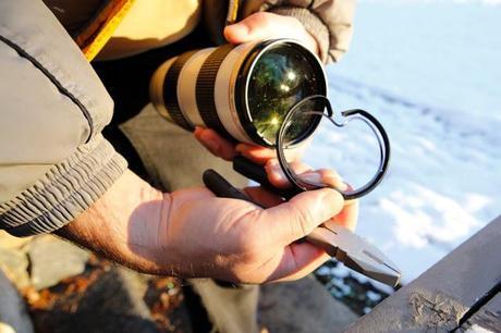 Salmon Arm, BC - Steps to remove a stuck lens filter: #5. Using pliers, bend/peel edges of filter rim into the centre of the filter to pull pressure off of inner threads of lens.  Start slowly and bend each piece slowly, but eventually, you'll wind up using considerable strength to break the inner ring enough to loosen it from the lens.