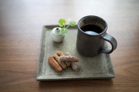 Una zuccheriera d'argento, una tazzina di caffè e due biscotti