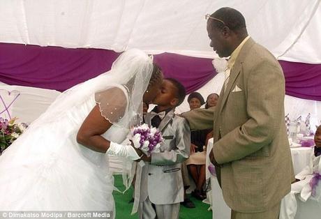 Ceremony: The schoolboy kisses his 61-year-old bride, who is already married and a mother of five. He said he had been told to tie the knot by his ancestors