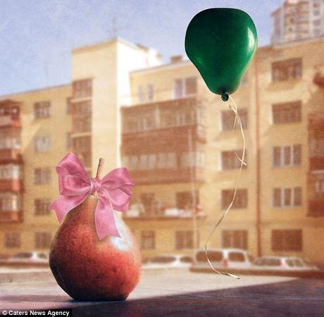 Baby pear: The fruit is dressed in a young girl's pink ribbon and pictured with a green balloon 