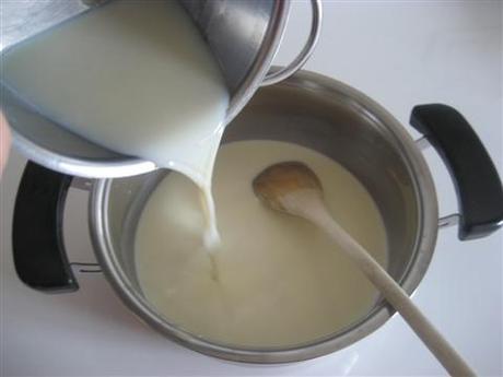 In un'altra ciotola sciogliere 2 cucchiai di miele nel latte freddo. Versare il latte-miele nella panna calda e continuare a mescolare.