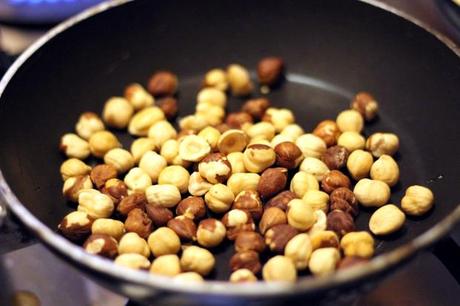 Nocciole tostate in padella per preparare il sugo degli gnocchi viola al gorgonzola