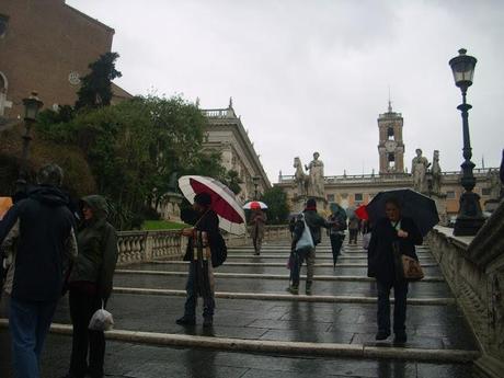 Umiliazione e perdita totale di dignità di una città. E i venditori abusivi di ombrelli sono arrivati ad occupare tutta la scalinata del Campidoglio