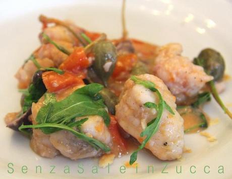 Rana pescatrice in guazzetto con olive, rucola e fiori di cappero