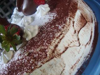 Torta al cioccolato con fragole e panna.