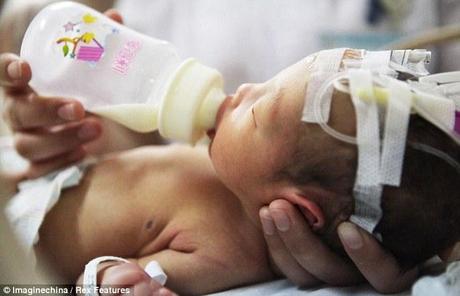 Essere guarito: Il bambino abbandonato è dipinto di essere alimentato in ospedale dopo i vigili del fuoco lo salvò da un tubo di depurazione dopo che era stato apparentemente lavata una toilette a Pujiang, provincia di Zhejiang, Cina