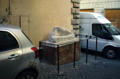 PIEDONE IN TRAPPOLA! IN VIA PIE' DI MARMO, L'ANTICO FRAMMENTO DI STATUA ROMANO OSTAGGIO DELLA SOSTA SELVATICA